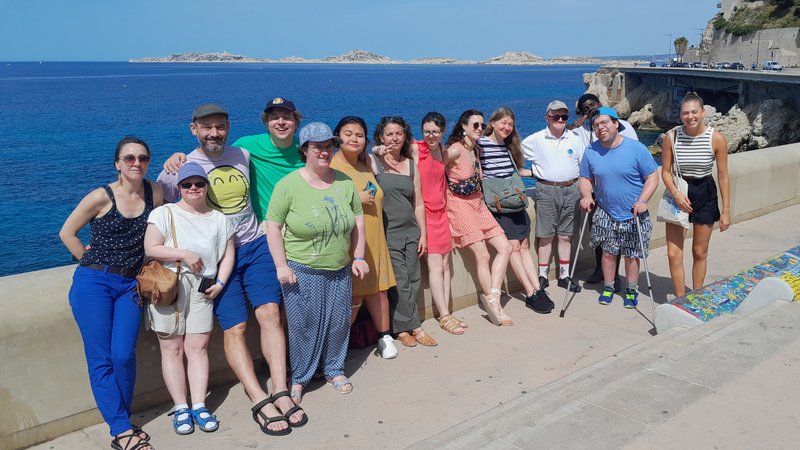 Die Reisegruppe und die französischen Gastgeber stehen am Meer.