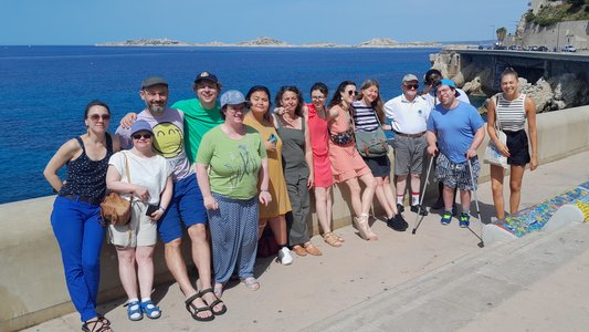 Die Reisegruppe und die französischen Gastgeber stehen am Meer.